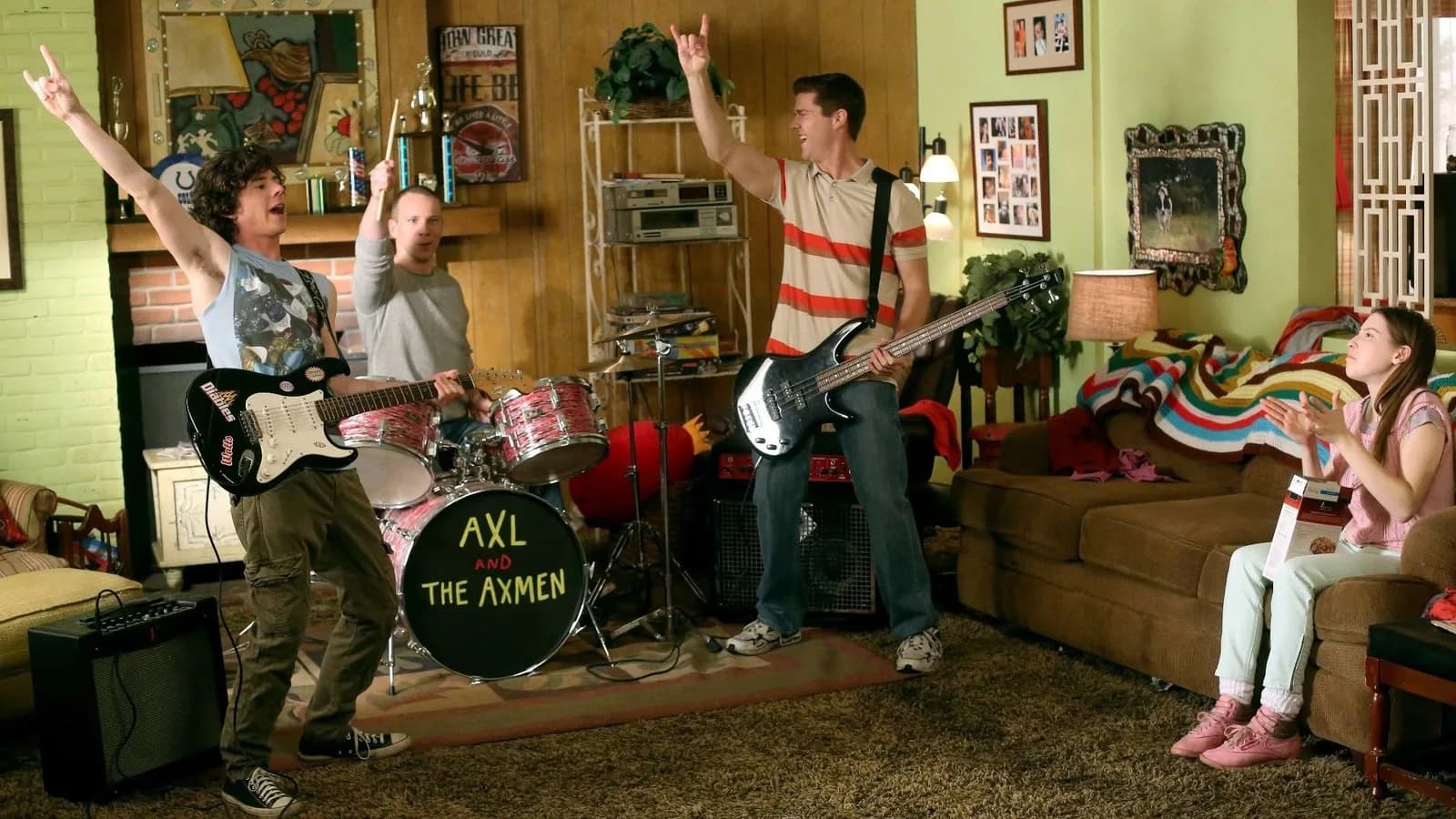 Axl and the Axmen playing music in a living room on The Middle