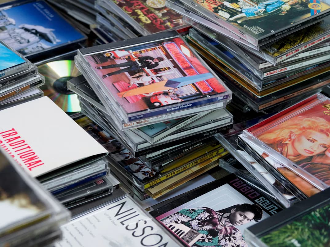 Stacks of music CDs spread across a table