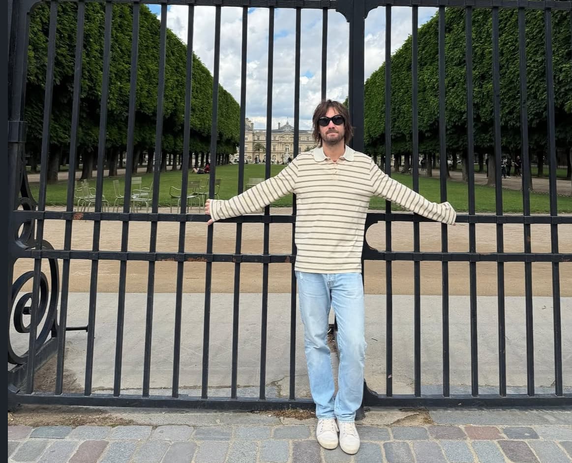 Kevin Parker standing in front of an ornate gate