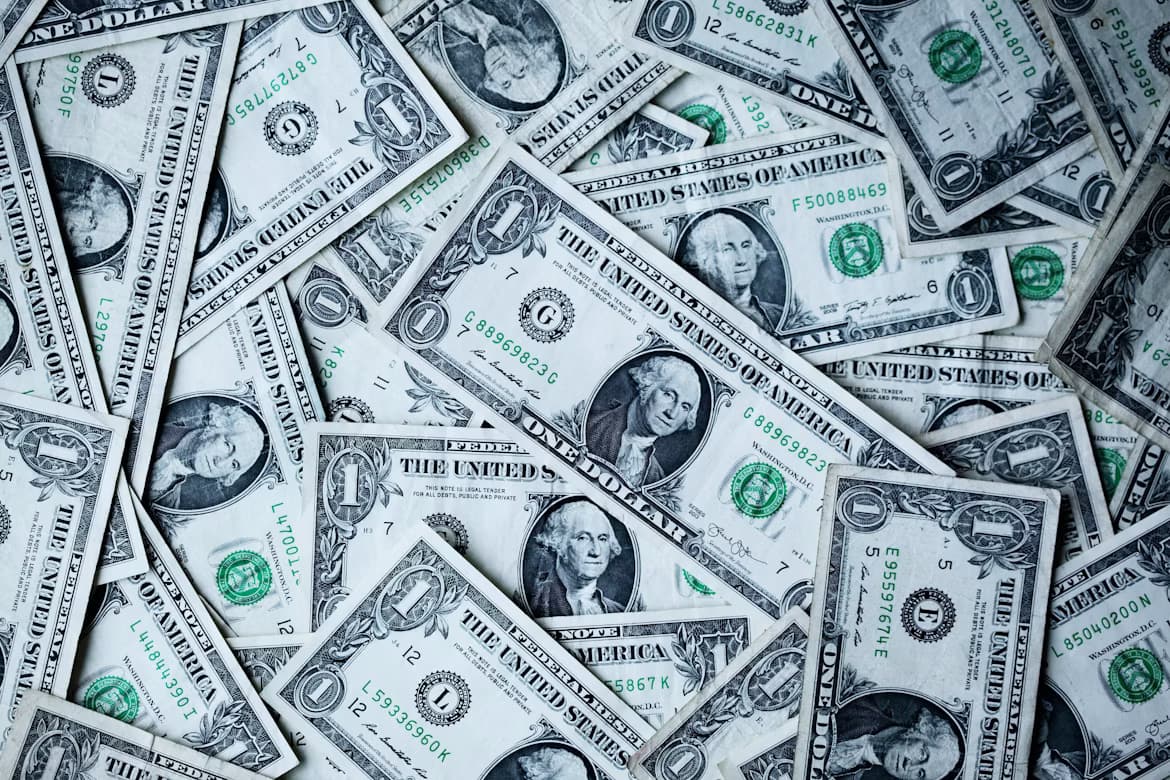 A scattered pile of one-dollar bills
