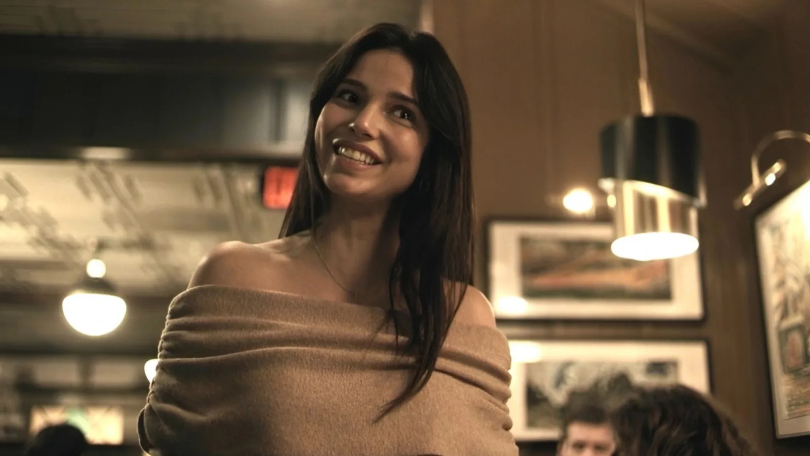 Nikki from Obsession smiling in a dimly lit scene